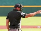 An umpire making a call during the major baseball rule change in a stadium today