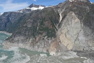 A massive cruise ship sailing near the steep glaciers of Tracy Arm Fjord in Alaska