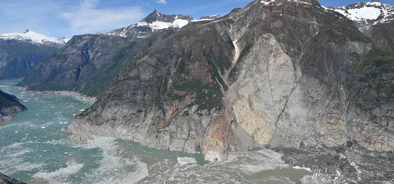 A massive cruise ship sailing near the steep glaciers of Tracy Arm Fjord in Alaska