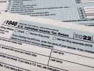 Official IRS tax forms sitting on a desk with US dollar bills