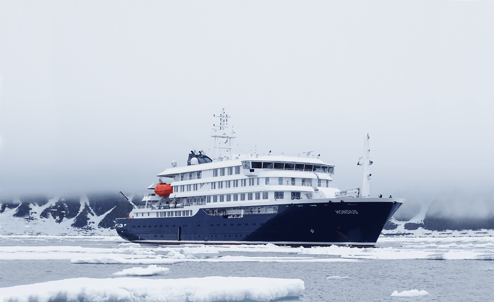 A large cruise ship sailing on the open ocean under cloudy skies