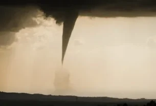 A massive dark tornado outbreak warning storm approaching a rural town
