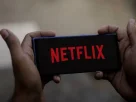 A phone displaying a Netflix account warning notice to users online