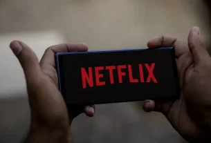 A phone displaying a Netflix account warning notice to users online