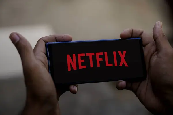 A phone displaying a Netflix account warning notice to users online