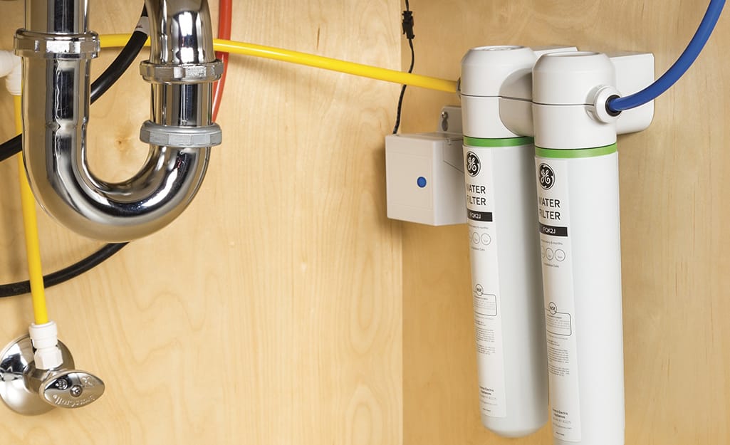 A person installing a filter to stay safe from the dangerous tap water alert