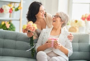 A happy mother receiving flowers and gifts for Mother's Day 2026