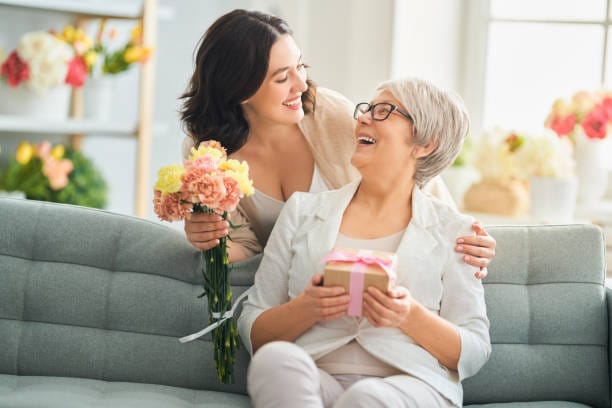 A happy mother receiving flowers and gifts for Mother's Day 2026