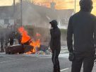 A burnt car showing the active Belfast anti immigrant violence and city protests today