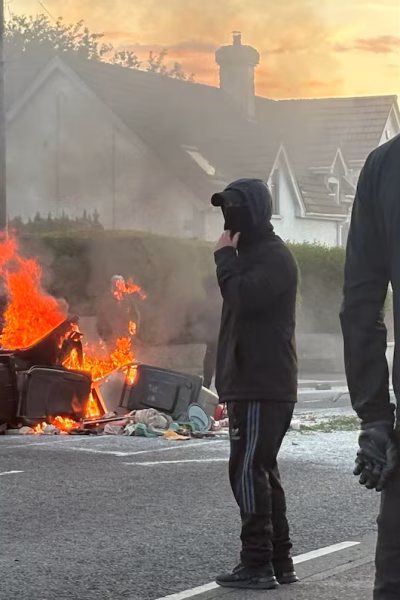A burnt car showing the active Belfast anti immigrant violence and city protests today