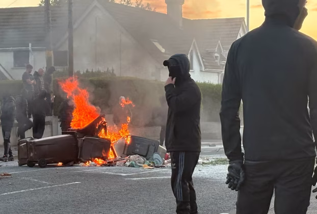 A burnt car showing the active Belfast anti immigrant violence and city protests today